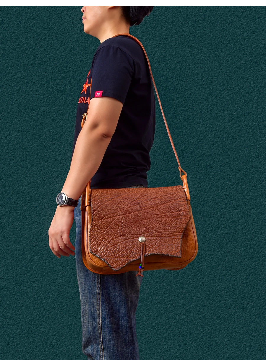 Vintage handmade genuine cowhide messenger bag in tan with a textured, asymmetrical flap and cross-body shoulder strap.