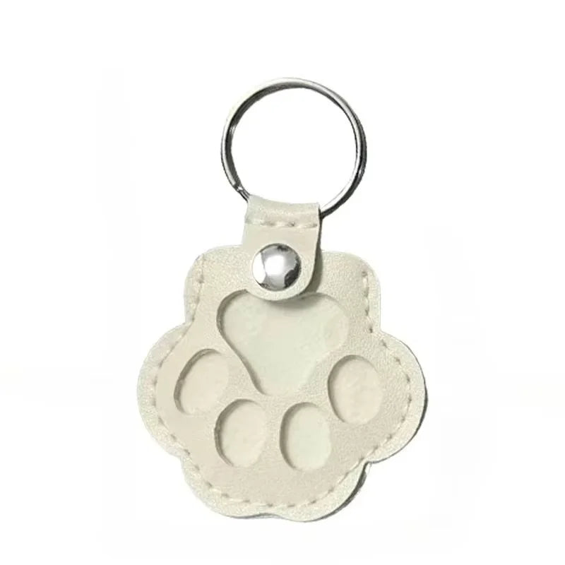 White leather pet hair storage keychain with cat paw design, perfect as a portable memorial bag pendant.