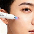 White handheld blue light skin tag and wart removal device being used on facial skin for clear, smooth results.